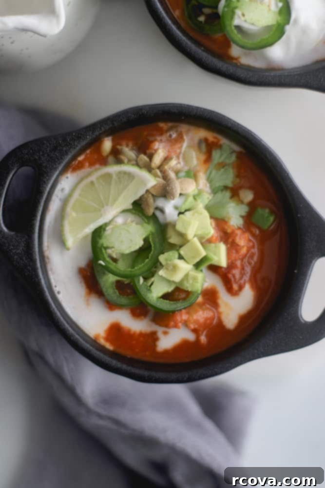 Effortless Halloween Dinners 9 Paleo pumpkin chili in a white bowl with toppings