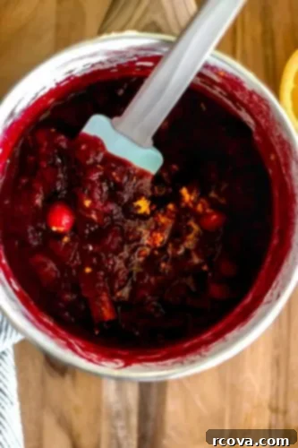 Honey-Kissed Orange Cranberry Sauce 7 Finished homemade cranberry sauce in a bowl with orange slices.