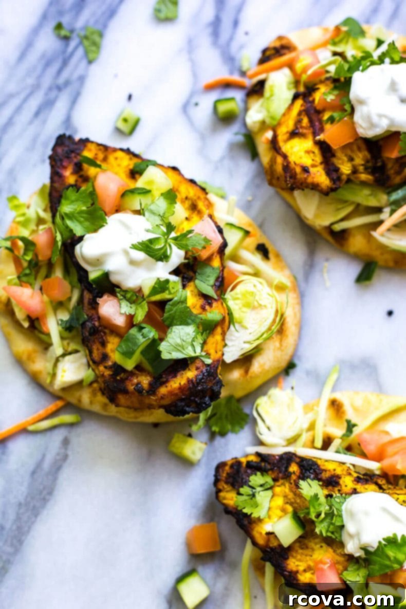 Tandoori Chicken Naan Burgers 5 Freshly assembled Indian-Inspired Chicken Naan Burgers with vibrant toppings, ready to be served.