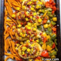 Golden Crispy Coconut Chicken Sheet Pan Dinner 9 Sheet Pan Coconut Crusted Chicken - Golden chicken on a plate with mango salsa and fries.