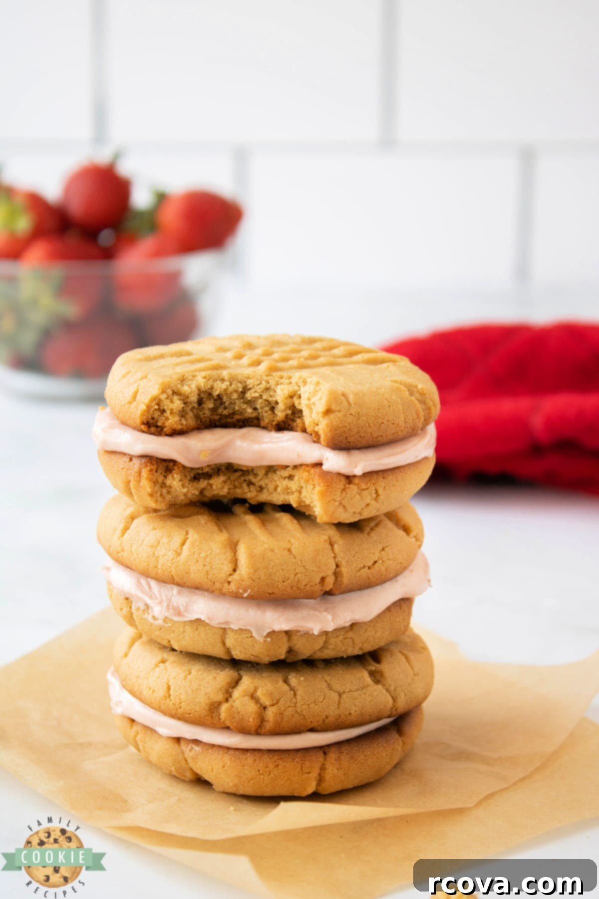 PB&J Cookie Delights 2 Peanut Butter and Jelly Sandwich Cookies are made by spreading a creamy strawberry buttercream frosting between two soft and chewy peanut butter cookies.  Your favorite childhood sandwich in the form of a dessert that everyone loves!