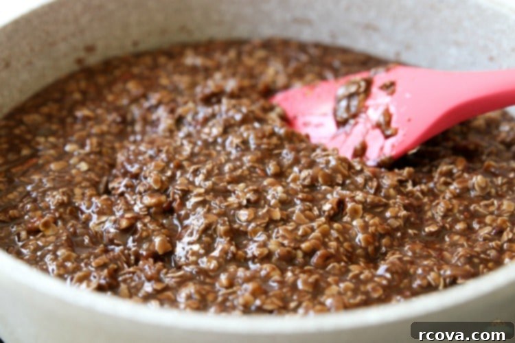 Decadent No-Bake Sweet Squares 5 Close-up of semi-sweet chocolate chips melting into a warm no-bake cookie base in a saucepan