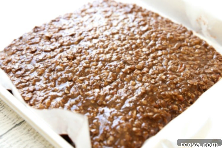 Decadent No-Bake Sweet Squares 6 No Bake Cookie Bars mixture spread evenly on a wax paper-lined baking sheet, cooling down