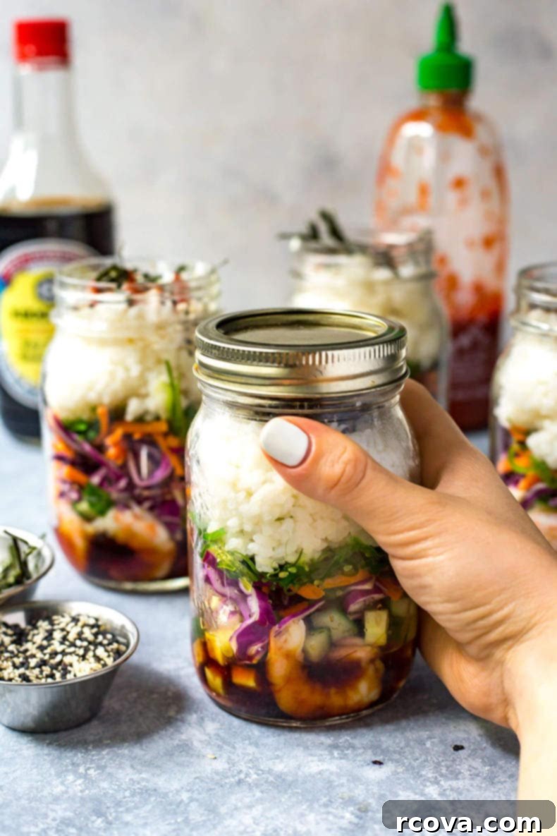 Meal Prep Dynamite Shrimp Sushi Jars 4 Close-up of sushi jars with layers of rice, shrimp, and vegetables