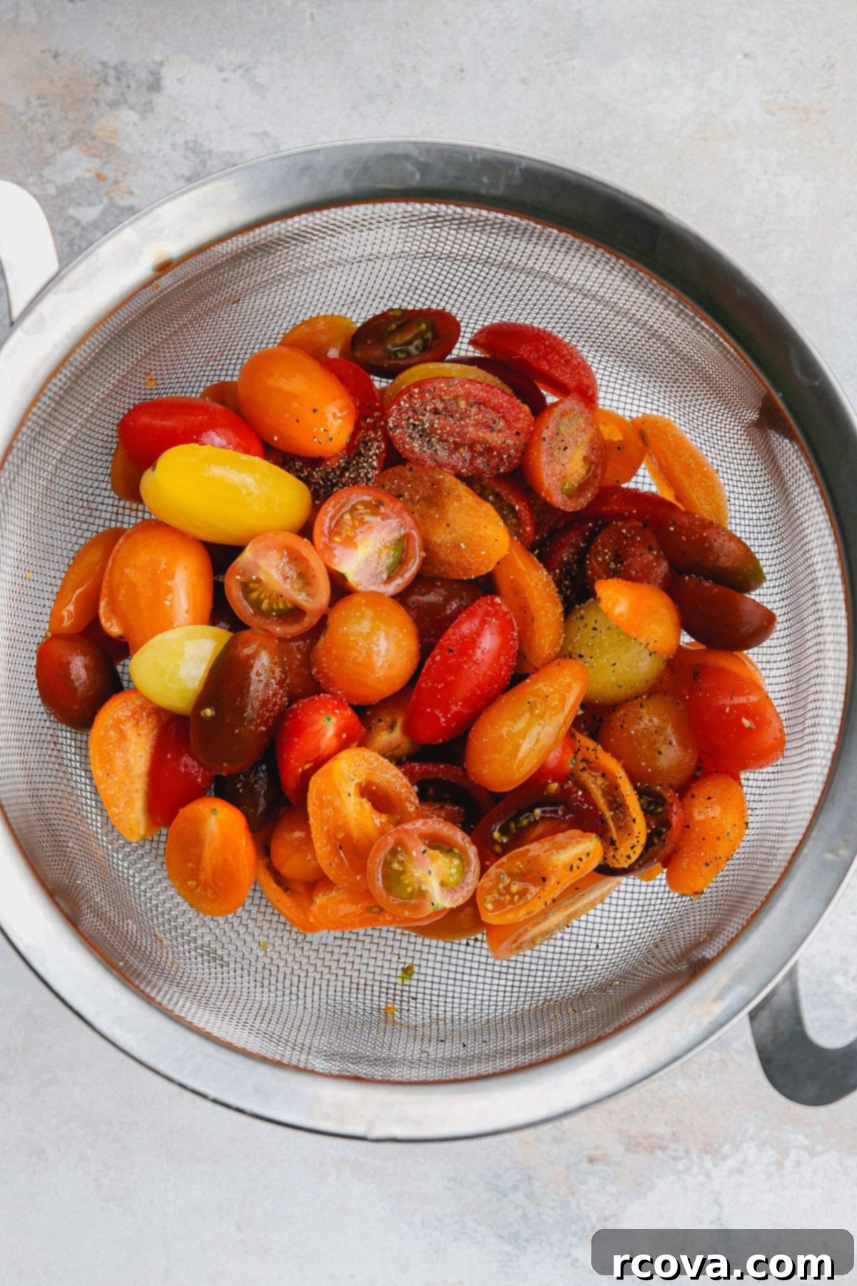 Smoky Corn and Tomato Panzanella 6 Halved cherry tomatoes in a strainer, salted with Kosher salt, draining over a bowl to collect tomato juice for the dressing.