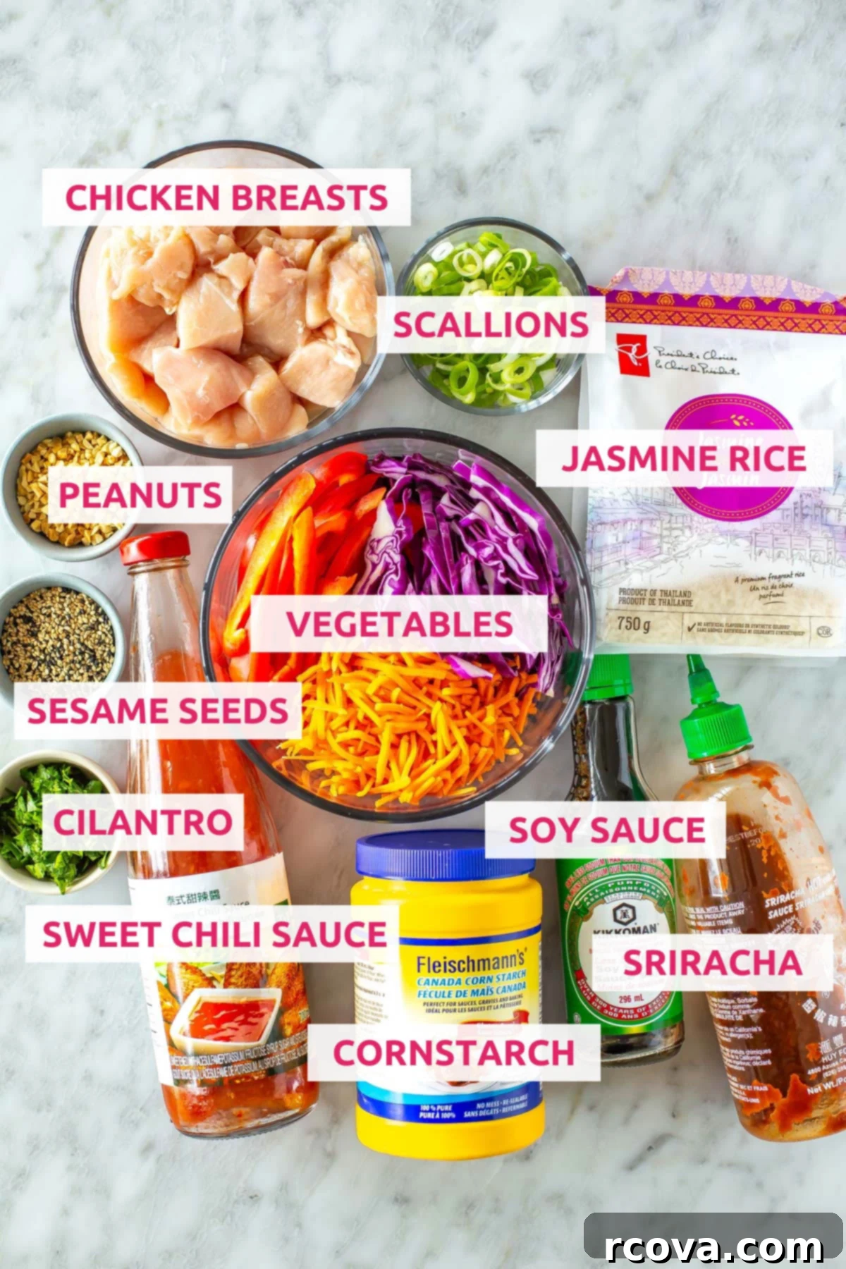 Grab-and-Go Sweet Chili Chicken Bowls 4 All the fresh ingredients for Sweet Chili Chicken Meal Prep Bowls laid out: cubed chicken breasts, jasmine rice, vibrant vegetables like matchstick carrots and red pepper, alongside sweet chili sauce, sriracha, soy sauce, and garnishes such as peanuts, scallions, sesame seeds, and fresh cilantro.