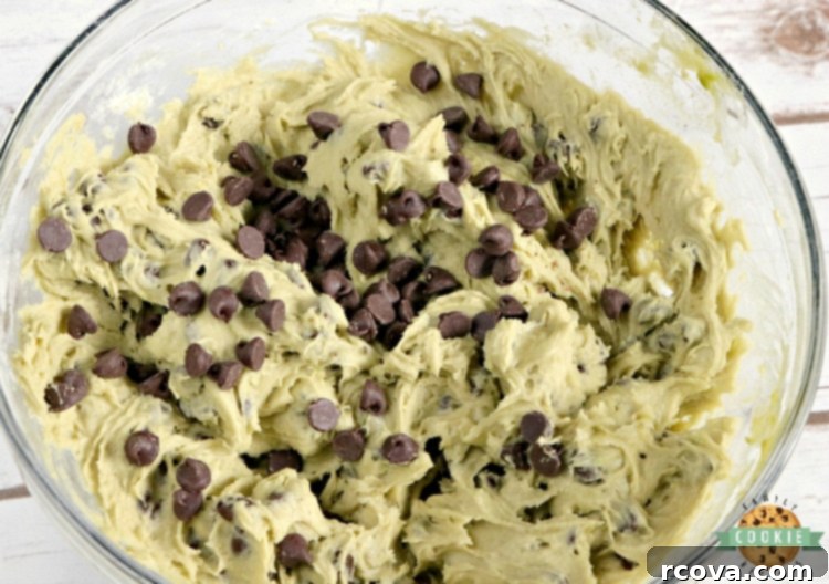 Fudgy Avocado Chocolate Chip Cookies 4 A stack of three avocado chocolate chip cookies on a cooling rack, highlighting their thick, perfectly baked texture.