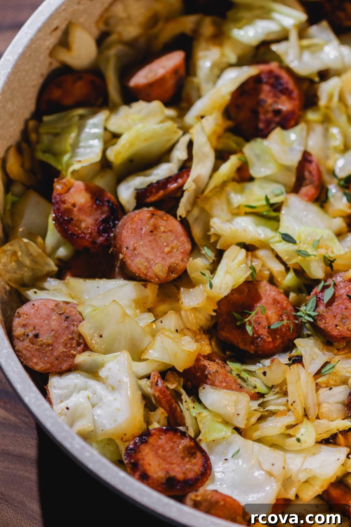 Easy Skillet Chicken Sausage and Cabbage 3 Close-up of chicken sausage and cabbage simmering in a cast iron skillet.