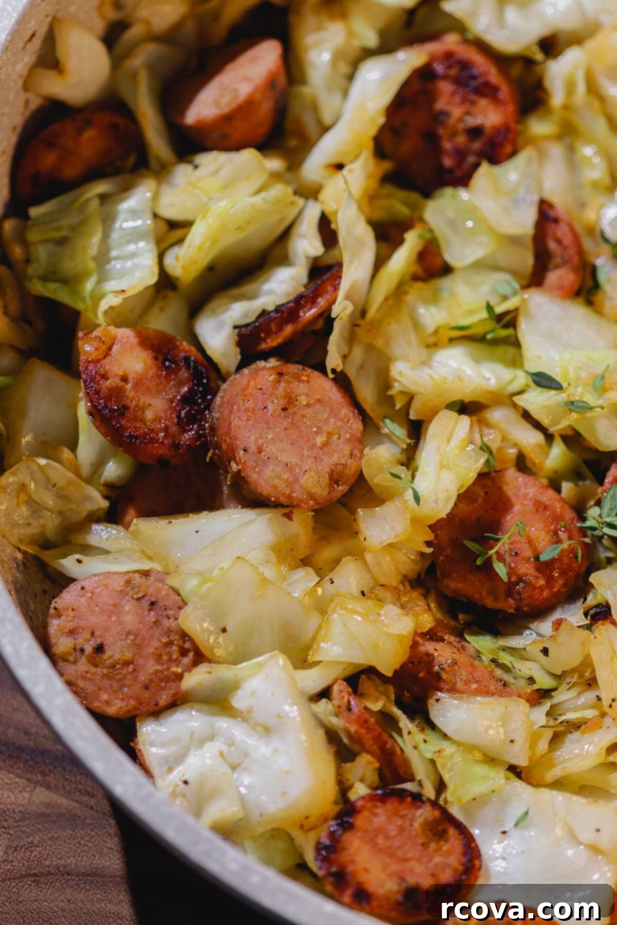 Easy Skillet Chicken Sausage and Cabbage 4 Sausage and cabbage cooking in a skillet, close-up.
