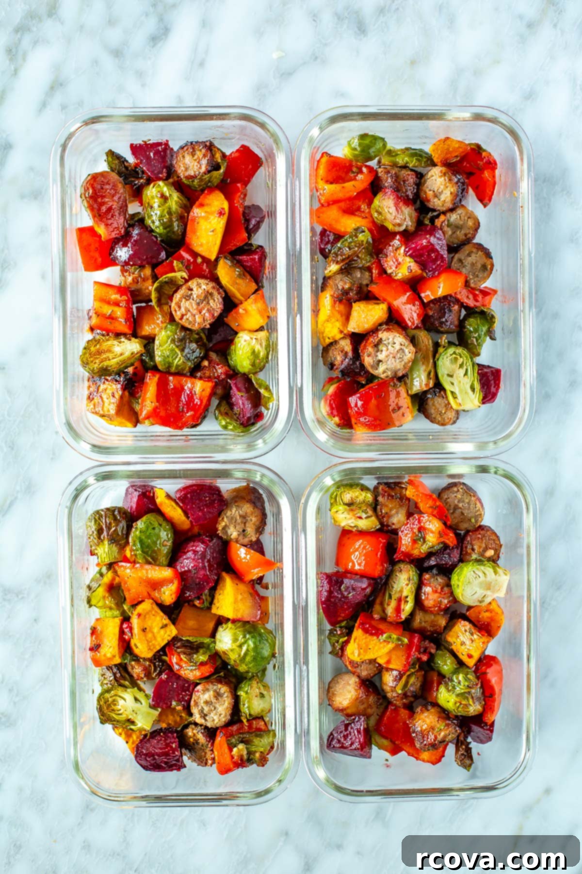 Sheet Pan Roasted Sausage and Vegetables 9 Four meal prep containers, each with a serving of vibrant sheet pan sausage and veggies, neatly arranged for weekly meals.