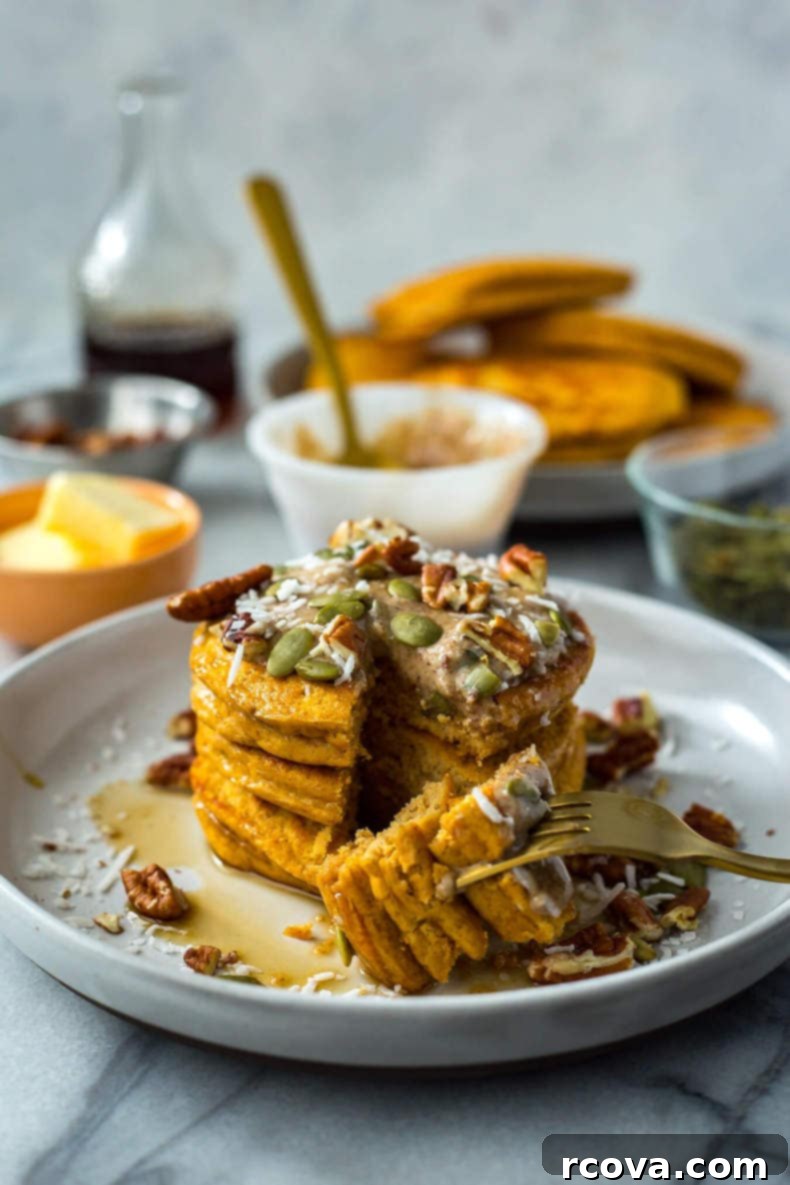 Easy 5-Ingredient Pumpkin Protein Pancakes 2 Stack of five 5-Ingredient Pumpkin Protein Pancakes drizzled with maple syrup and topped with whipped cream and pumpkin seeds, set against a cozy fall backdrop.