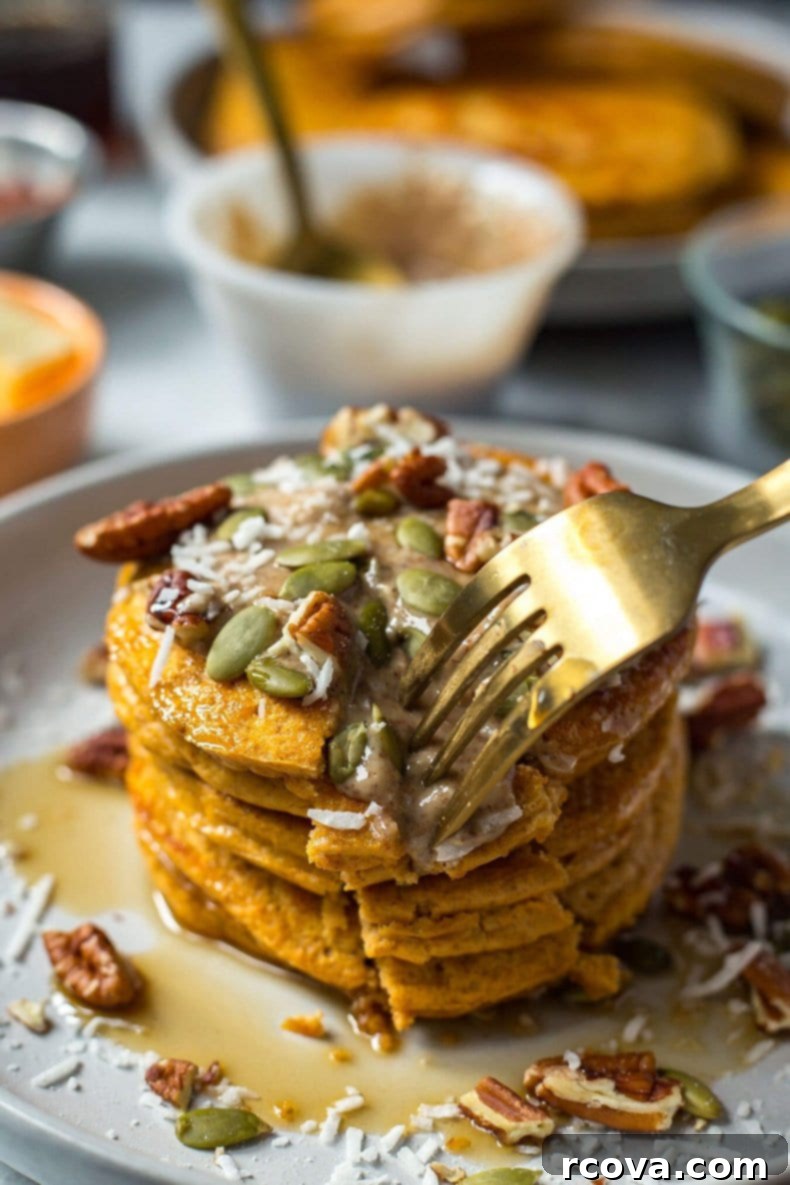 Easy 5-Ingredient Pumpkin Protein Pancakes 7 A beautifully presented stack of 5-Ingredient Pumpkin Protein Pancakes with a generous topping of whipped cream, maple syrup, and a sprinkle of pumpkin seeds.
