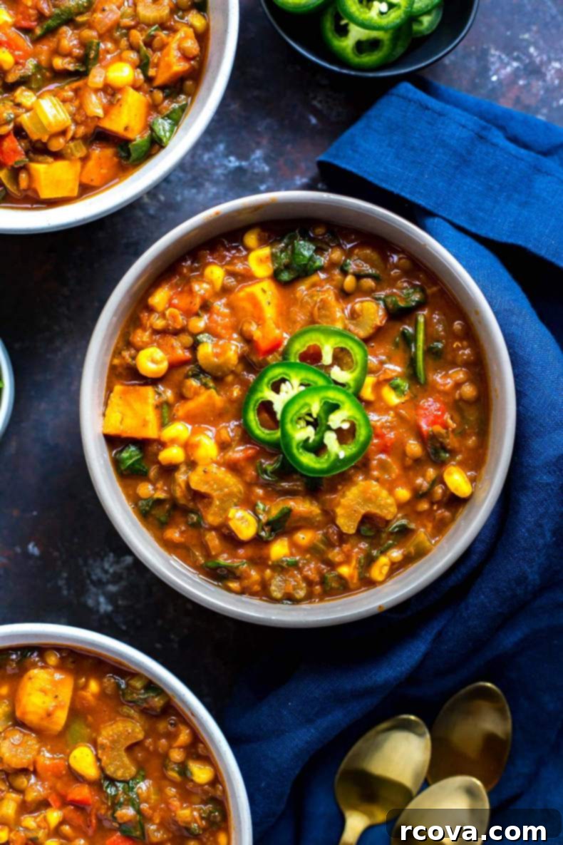 Hearty Slow Cooker Vegetarian Lentil Chili 5 A bowl of Slow Cooker Sweet Potato Lentil Chili with fresh herbs on a rustic wooden background.