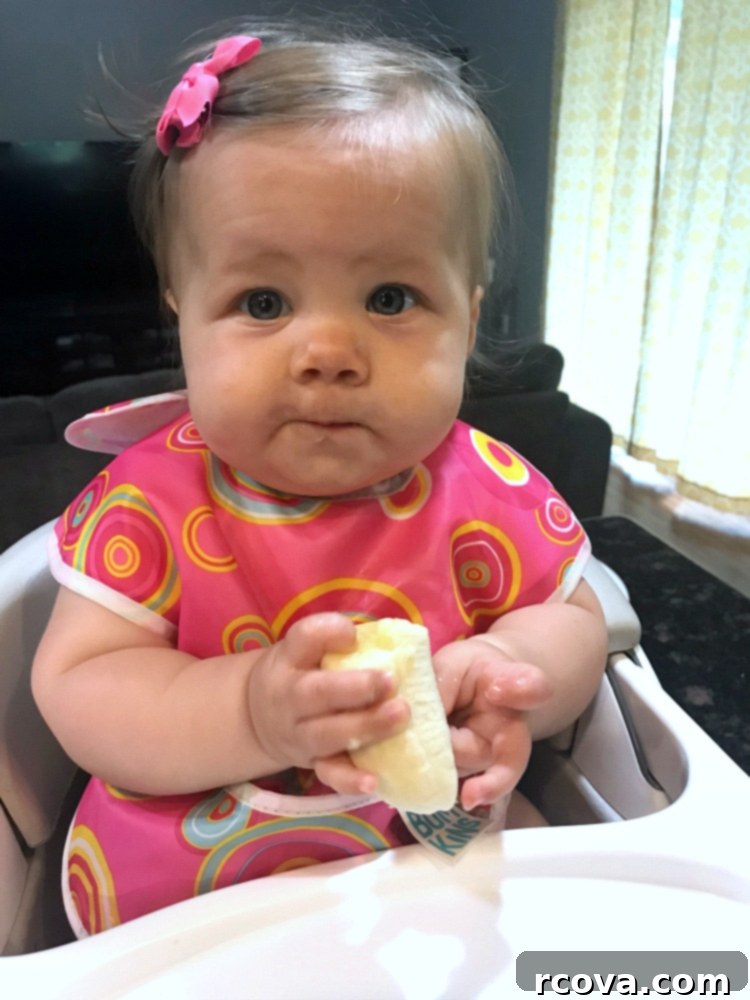 Dark Chocolate Cherry Indulgence 12 Adorable baby Brooklyn happily enjoying a banana, reflecting the joys of family and sharing food.