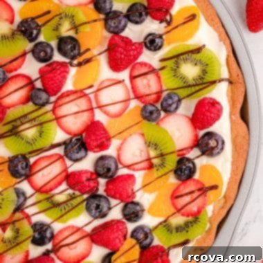 Giant Chocolate Chip Cookie Fruit Pizza 8 Vibrant chocolate chip cookie pizza generously topped with an assortment of fresh fruits, showcasing a delightful dessert.