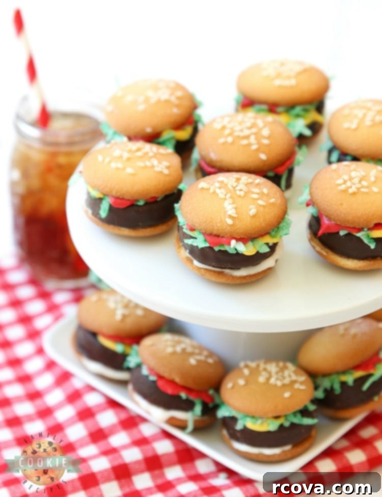 Slider Cookies 4 A close-up of a finished no-bake mini hamburger cookie, showing the layers of Nilla Wafers, Peppermint Patty, and colorful melted chocolate 'condiments' with green coconut 'lettuce' and sesame seeds.