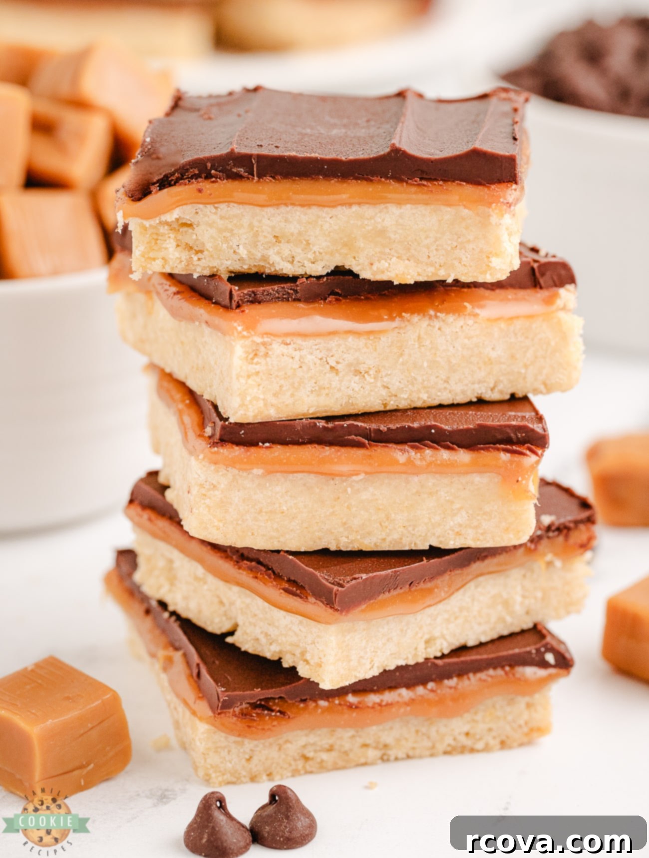 Chocolate Caramel Shortbread Bliss 5 A stack of perfectly cut homemade Twix shortbread cookie bars, showing off their distinct layers of golden shortbread, gooey caramel, and rich chocolate