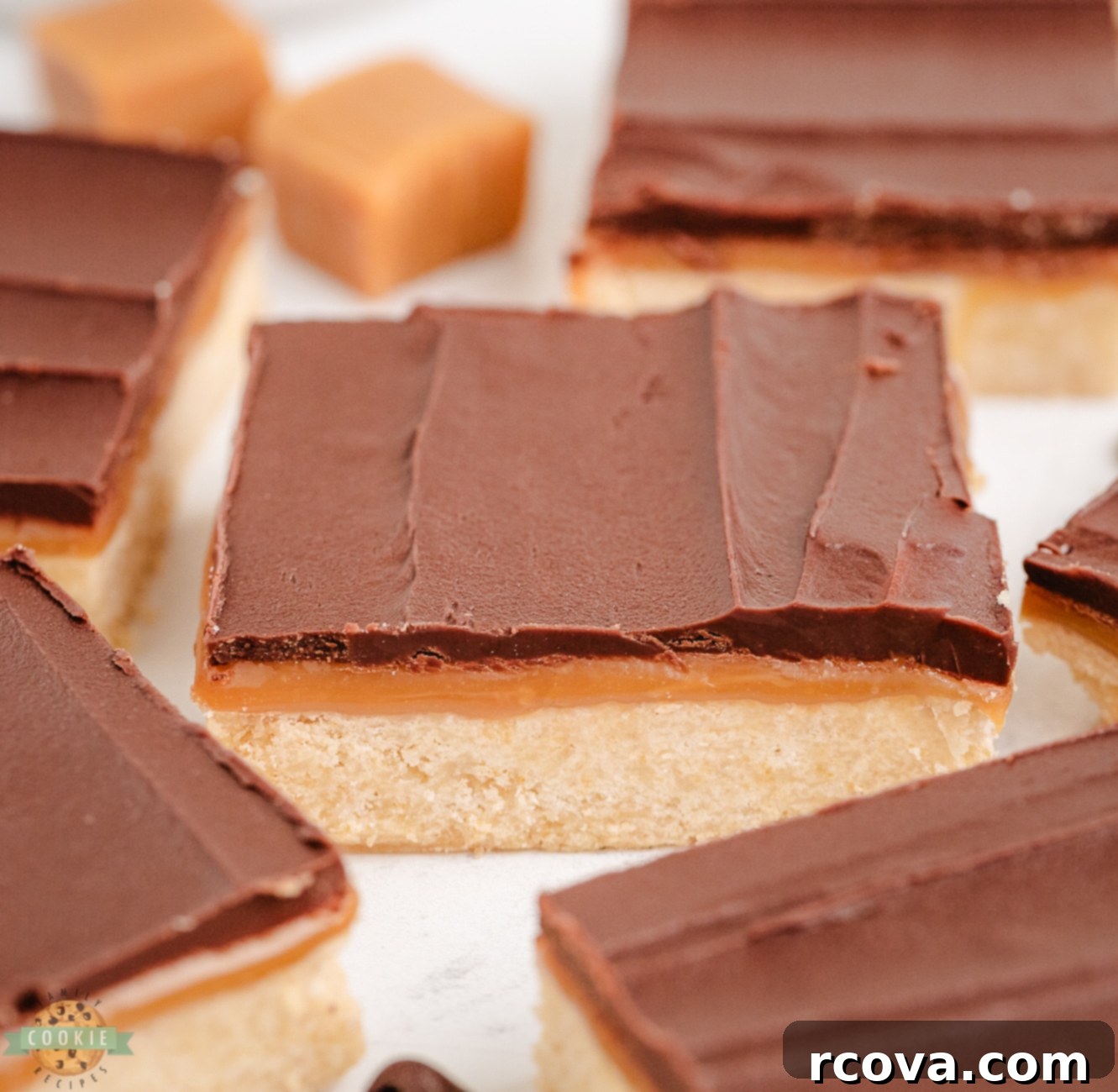 Chocolate Caramel Shortbread Bliss 7 Beautifully cut homemade Twix copycat cookie bars arranged in squares, showcasing the distinct shortbread, caramel, and chocolate layers