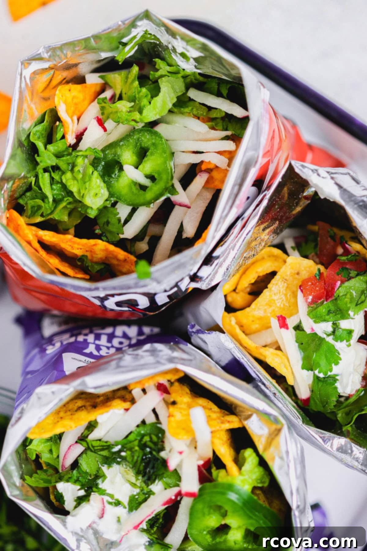 Kick Off Your Football Party With Ultimate Walking Tacos 2 walking tacos: taco meat with beans in a bag of Doritos or Fritos with taco toppings