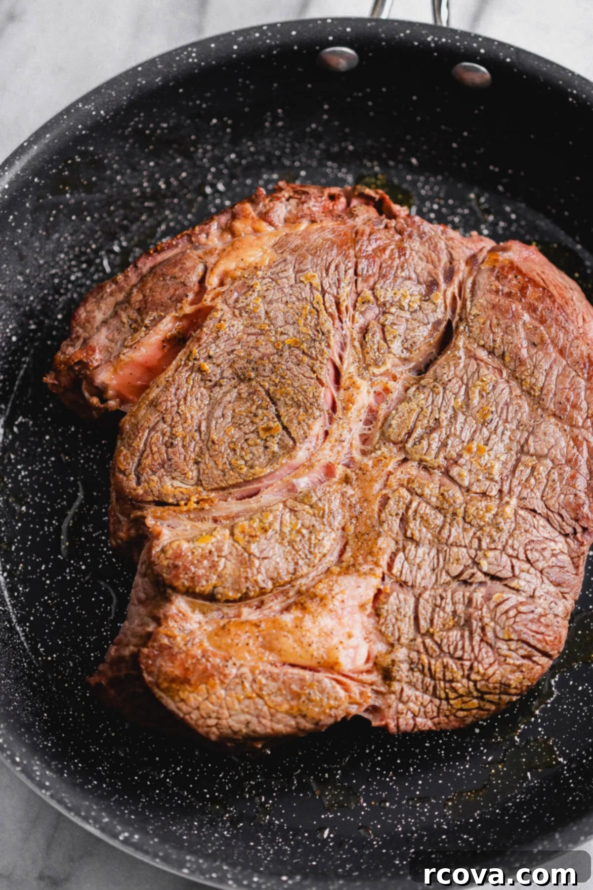Set-It-and-Forget-It Slow Cooker Pot Roast 5 Chuck roast searing in a skillet with salt and pepper