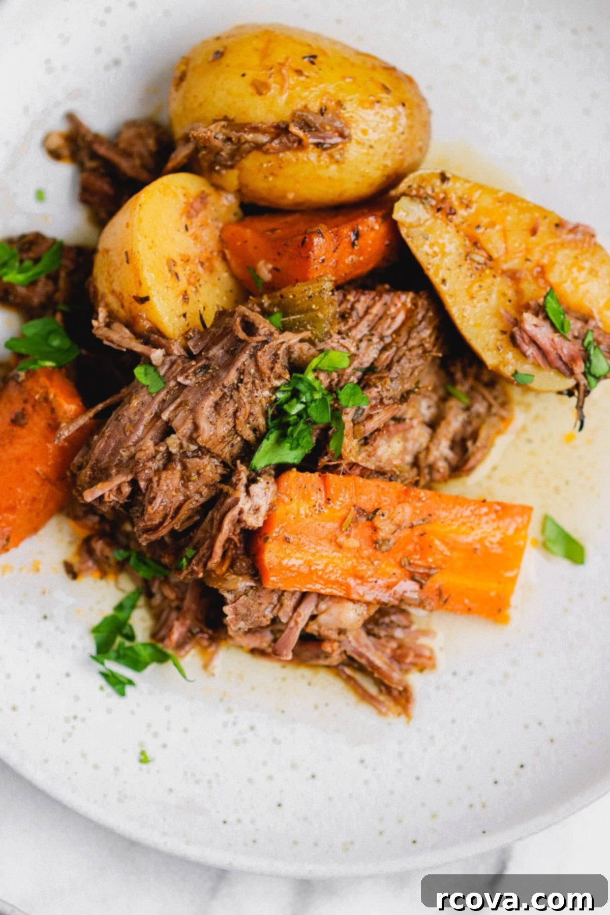 Set-It-and-Forget-It Slow Cooker Pot Roast 7 Close up of fork-tender slow cooker pot roast with potatoes and carrots, ready to serve.