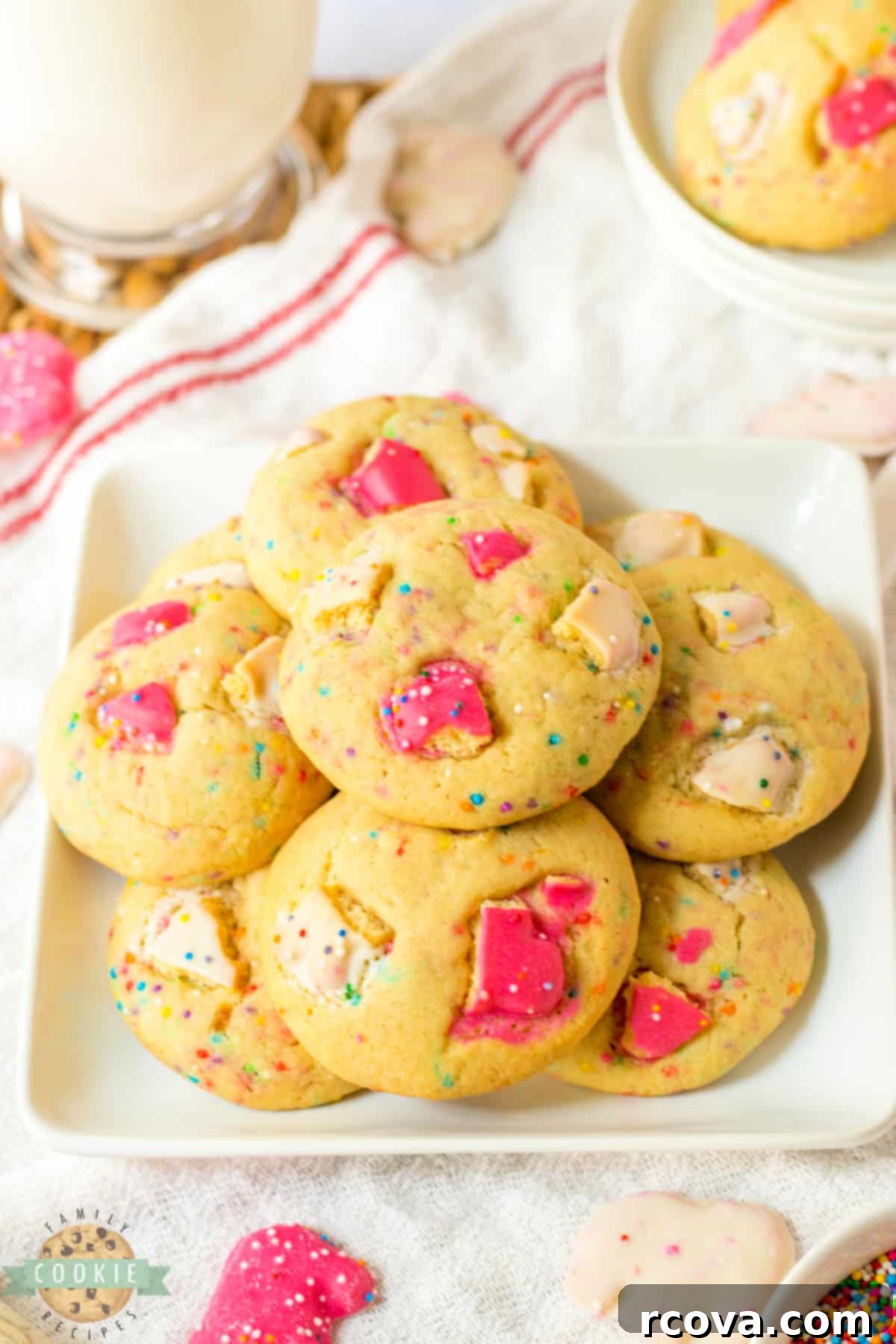 Whimsical Circus Animal Sugar Cookies 2 A close-up of delicious Circus Animal Sugar Cookies, adorned with pink and white frosting, colorful sprinkles, and pieces of frosted animal crackers, on a light background. These cookies are a fun and whimsical twist on traditional sugar cookies.