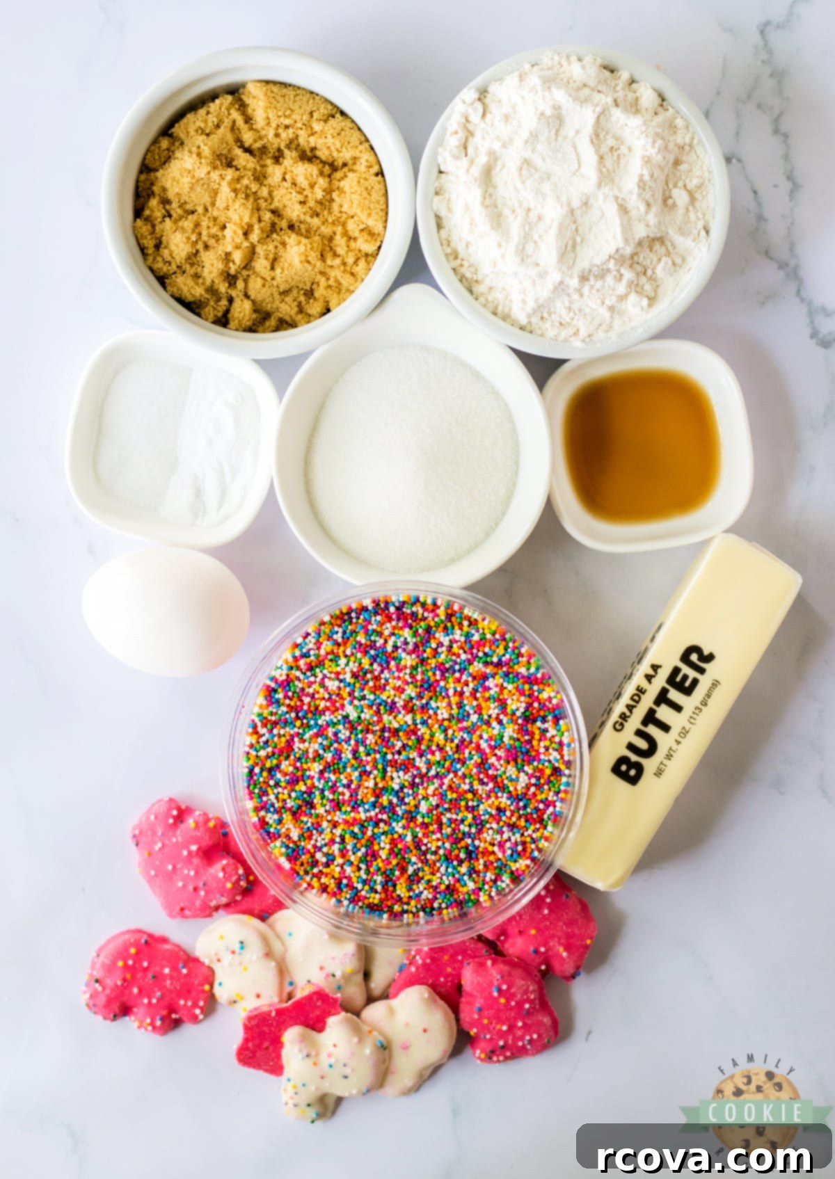 Whimsical Circus Animal Sugar Cookies 4 Assorted ingredients for Circus Animal Sugar Cookies laid out on a kitchen counter: butter, sugars, egg, vanilla, flour, baking soda, salt, rainbow sprinkles, and frosted animal cookies.