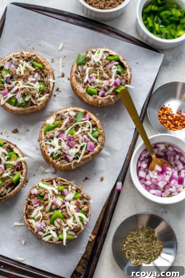 Effortless Low Carb Portobello Pizza Caps 4 Two fully loaded Portobello mushroom pizzas, showcasing melted cheese and fresh toppings