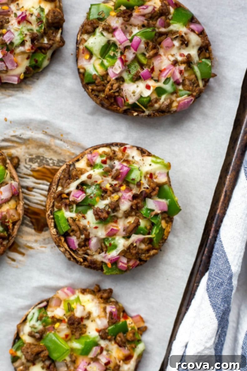 Effortless Low Carb Portobello Pizza Caps 6 Four Portobello mushroom pizzas arranged neatly on a baking sheet after baking