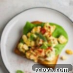 Zesty Celery and Pickle Juice Egg Salad 6 A serving of egg salad on toast, garnished with fresh dill.