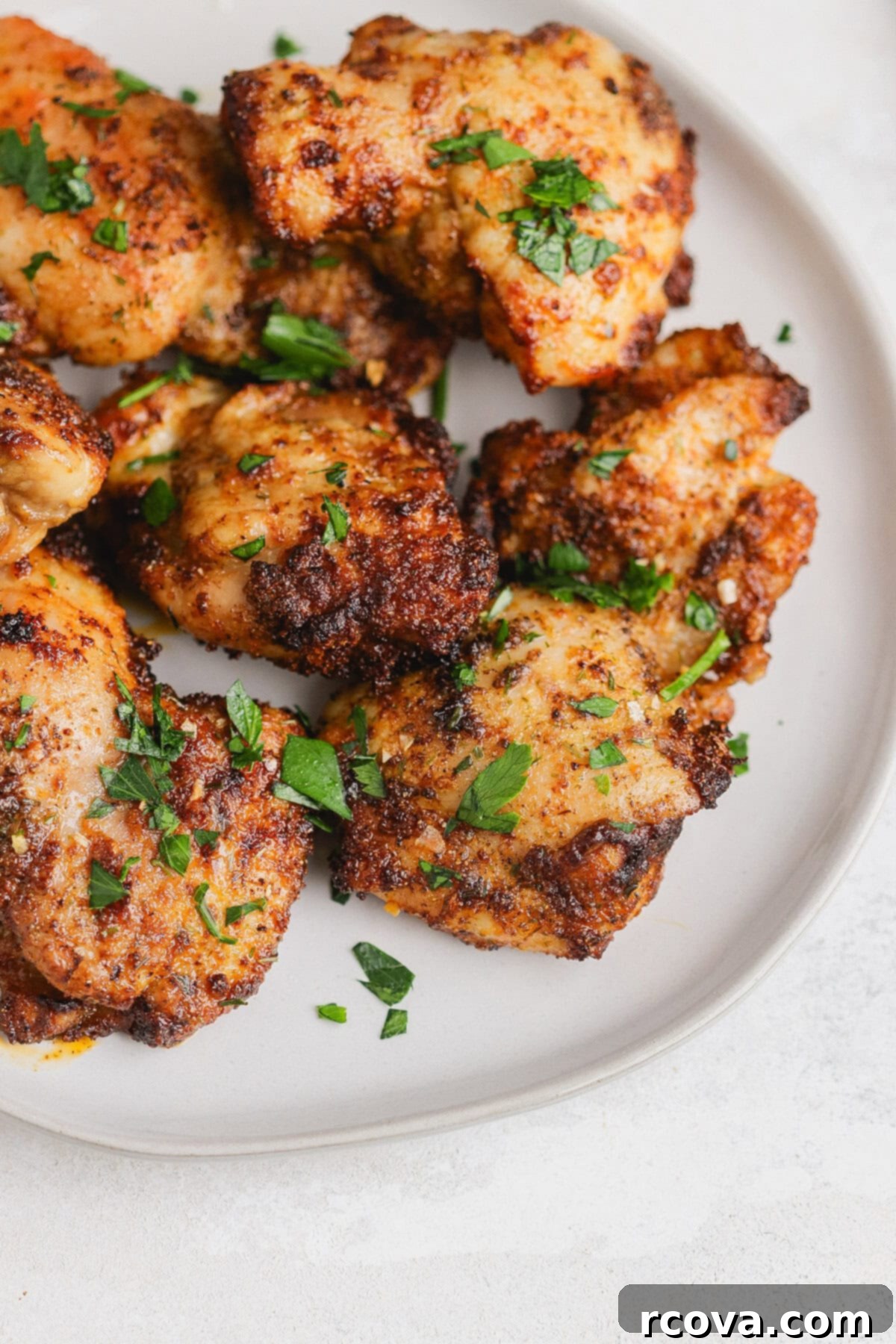Crispy Air Fryer Chicken Thighs 2 Crispy and juicy boneless skinless chicken thighs cooked to perfection in an air fryer, served on a plate.