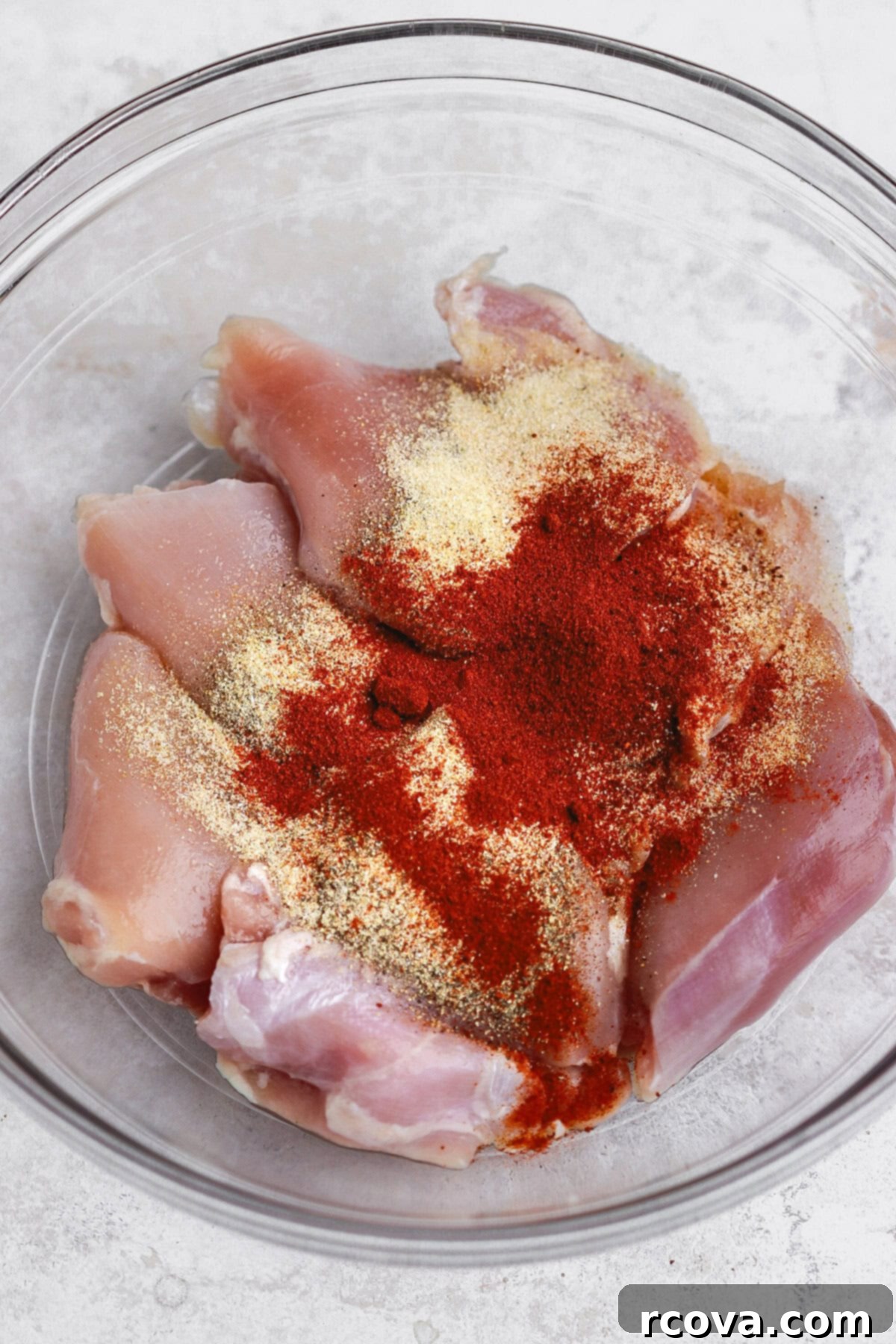 Crispy Air Fryer Chicken Thighs 3 A bowl of boneless skinless chicken thighs with spices and seasoning, ready for the air fryer.