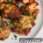 Crispy Air Fryer Chicken Thighs 6 Air Fryer Boneless Skinless Chicken Thighs on a plate with fresh herbs