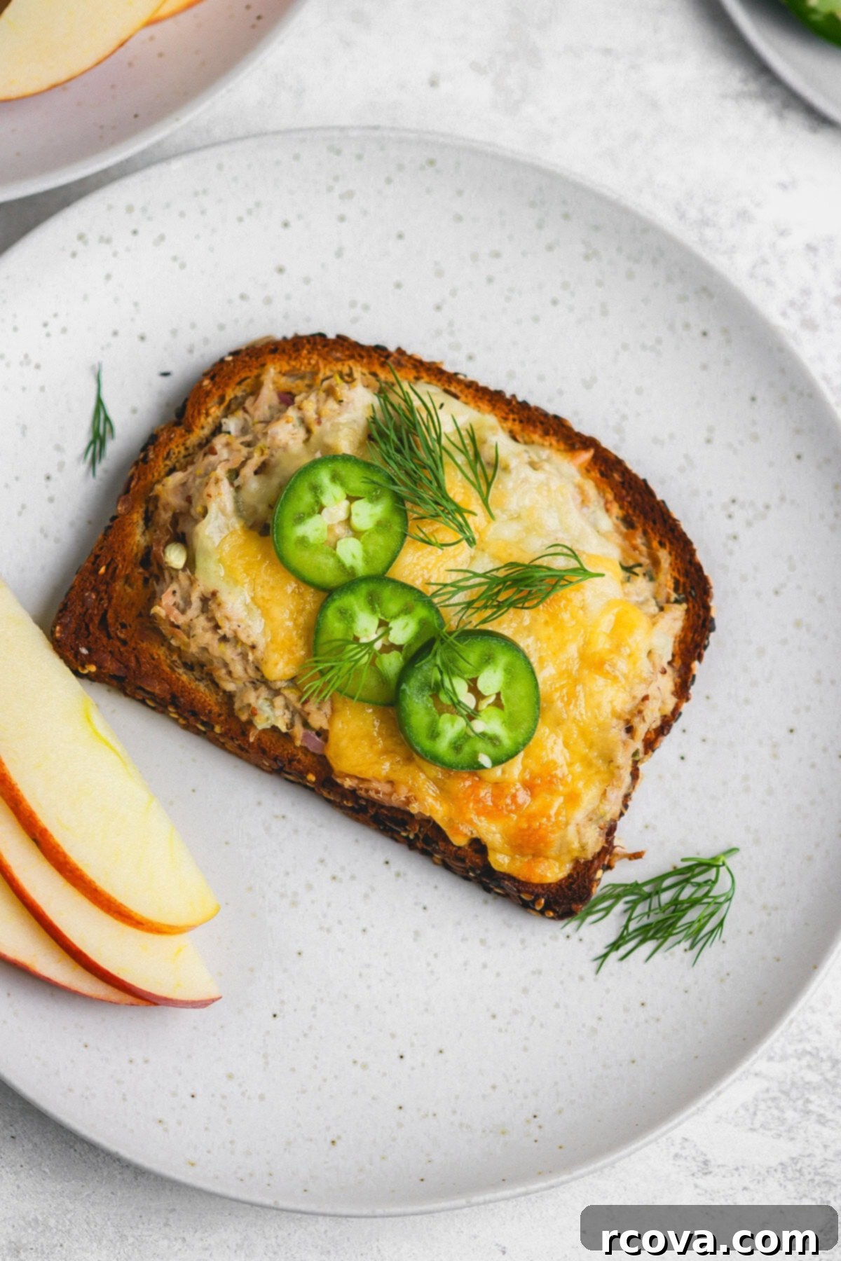 Jalapeño Zing Tuna Melt 2 A perfectly toasted spicy tuna melt sandwich, golden brown with melted cheddar and a hint of jalapeño.