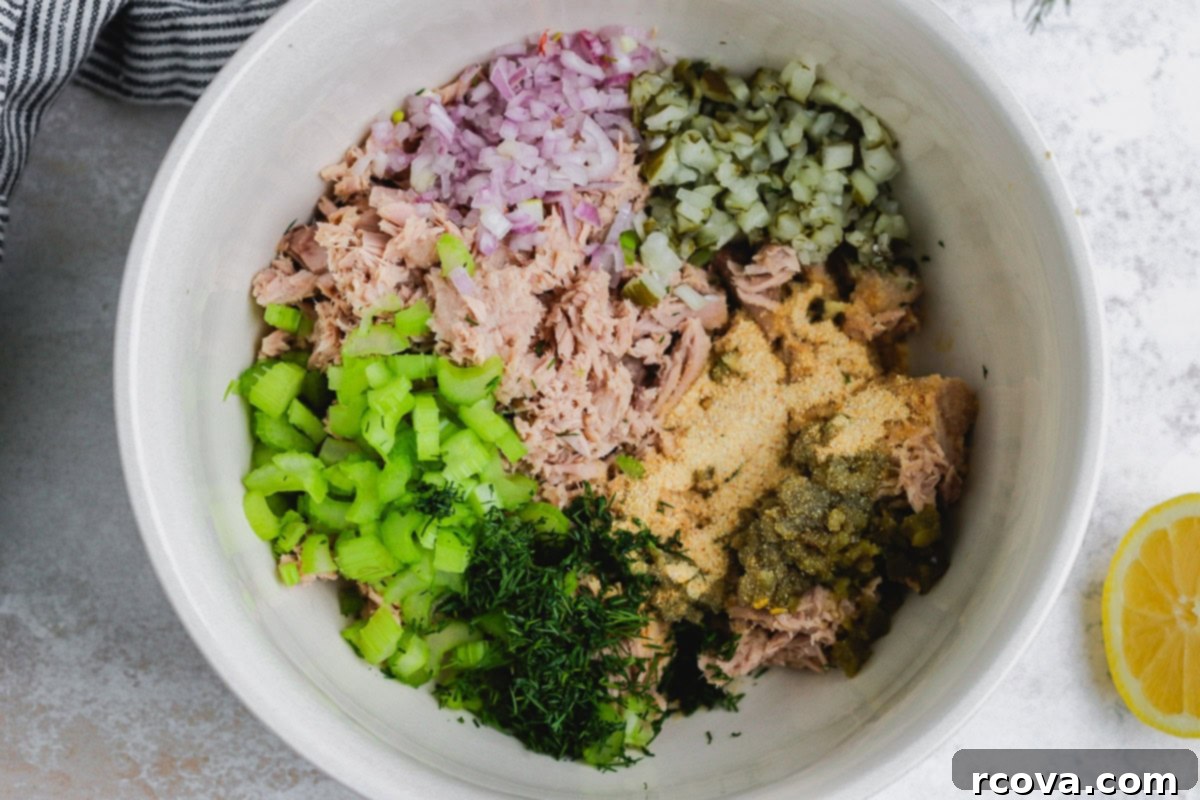 Jalapeño Zing Tuna Melt 3 A bowl filled with canned tuna, finely chopped red onions, and other fresh ingredients, ready to be mixed into tuna salad.