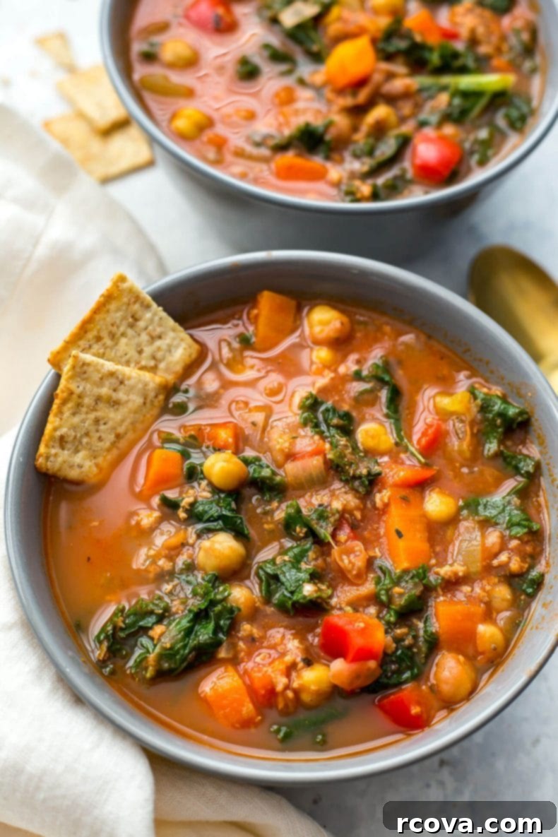 Hearty Tuscan Sausage and Kale Slow Cooker Soup 5 A bowl of Slow Cooker Tuscan Sausage and Kale Soup with crusty bread