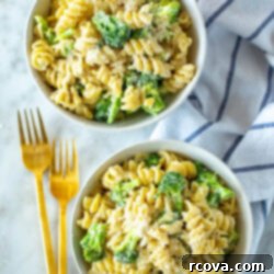 Creamy One-Pot Broccoli Alfredo Pasta 11 Two bowls of creamy One-Pot Broccoli Alfredo Pasta with cutlery next to them.