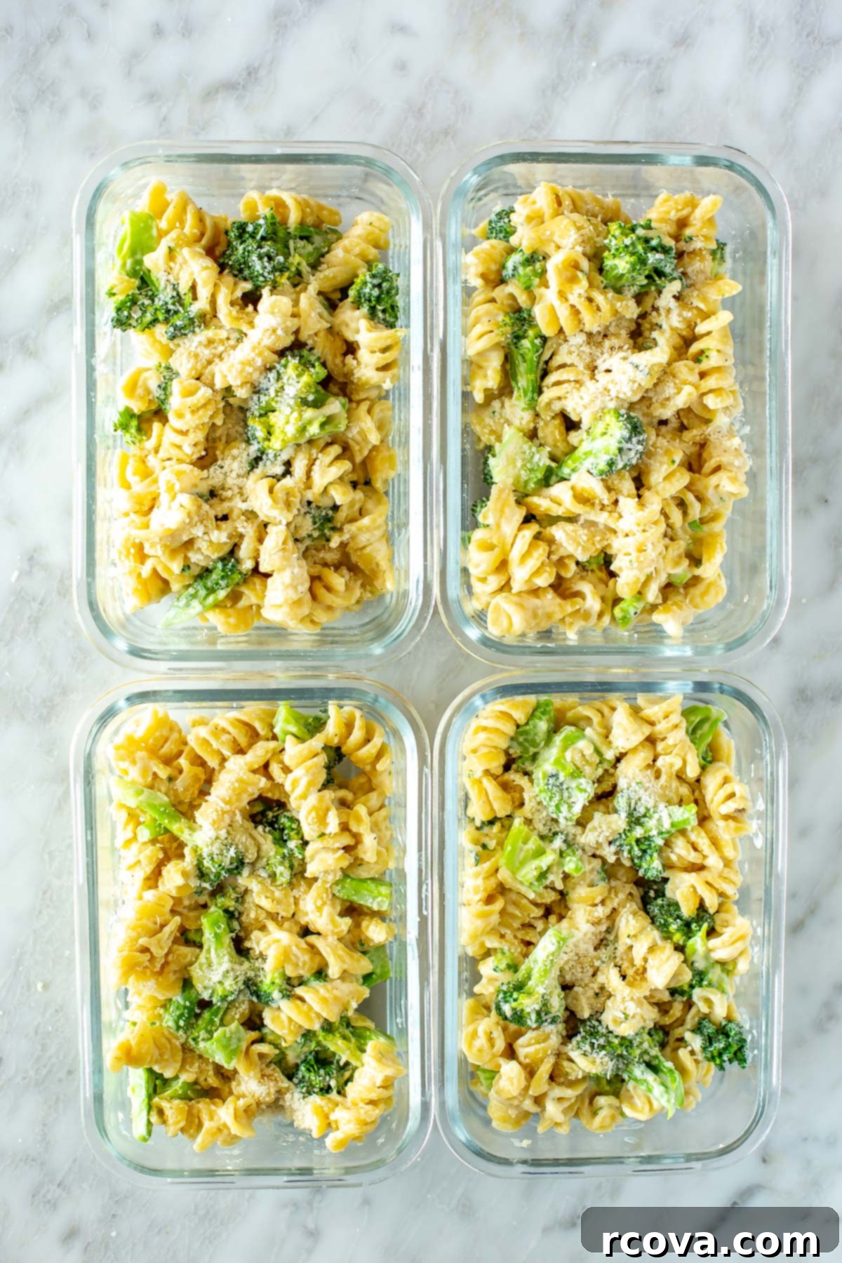 Creamy One-Pot Broccoli Alfredo Pasta 10 Four glass meal prep containers, each perfectly portioned with creamy one-pot broccoli alfredo pasta, ready for grab-and-go meals.