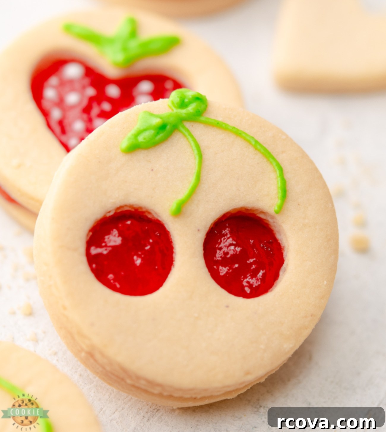 Fruit-Kissed Linzer Cookies 2 Close-up of a cherry cut-out Linzer cookie showing the vibrant jam filling