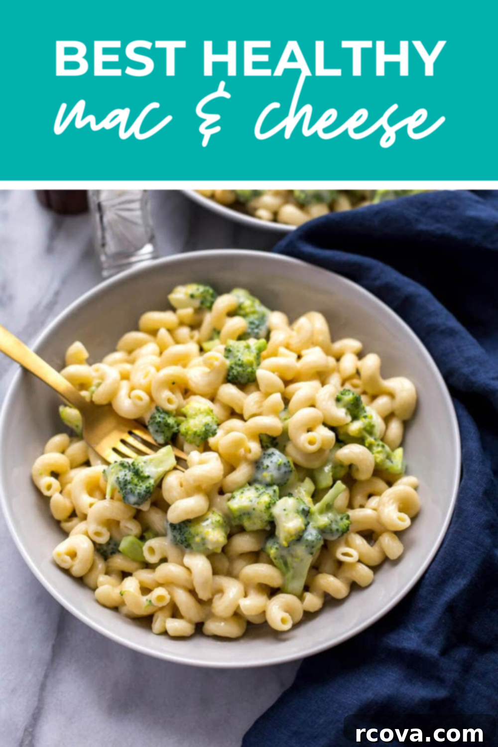 Wholesome Broccoli Mac and Cheese 12 A single white bowl of healthy mac and cheese with broccoli, with a spoon, on a light wooden table.