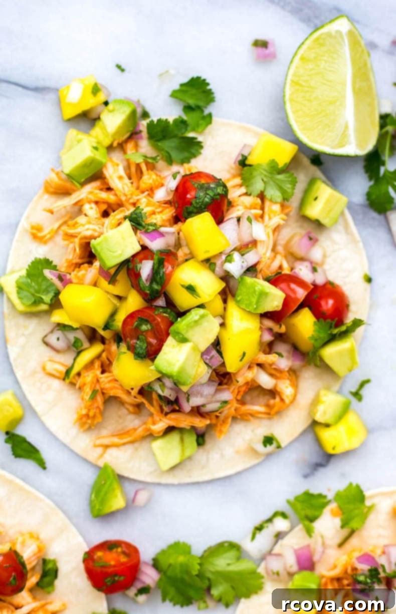 Spicy Instant Pot Sriracha Chicken Tacos 6 Assembled Instant Pot Sriracha Chicken Tacos with mango salsa on soft tortillas