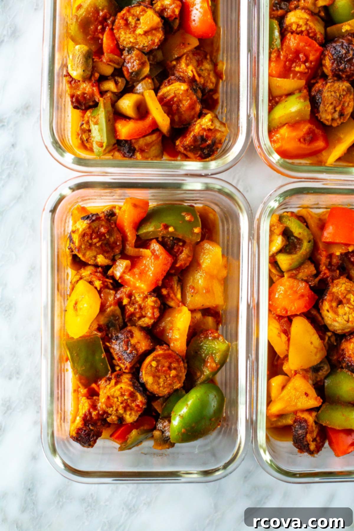 One-Pan Sausage, Peppers and Onions 9 A close-up shot of multiple meal prep containers, each perfectly portioned with the colorful and hearty sausage, peppers, and onions skillet, ready for the week.