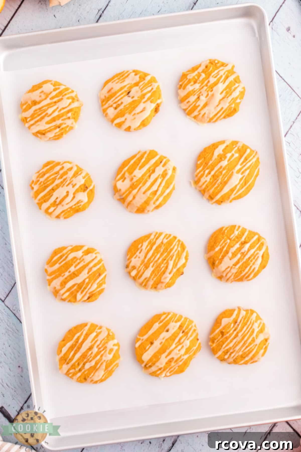 Golden Pumpkin Cookies 3 A close-up of a pumpkin cookie recipe with a bright orange glaze drizzled over it.