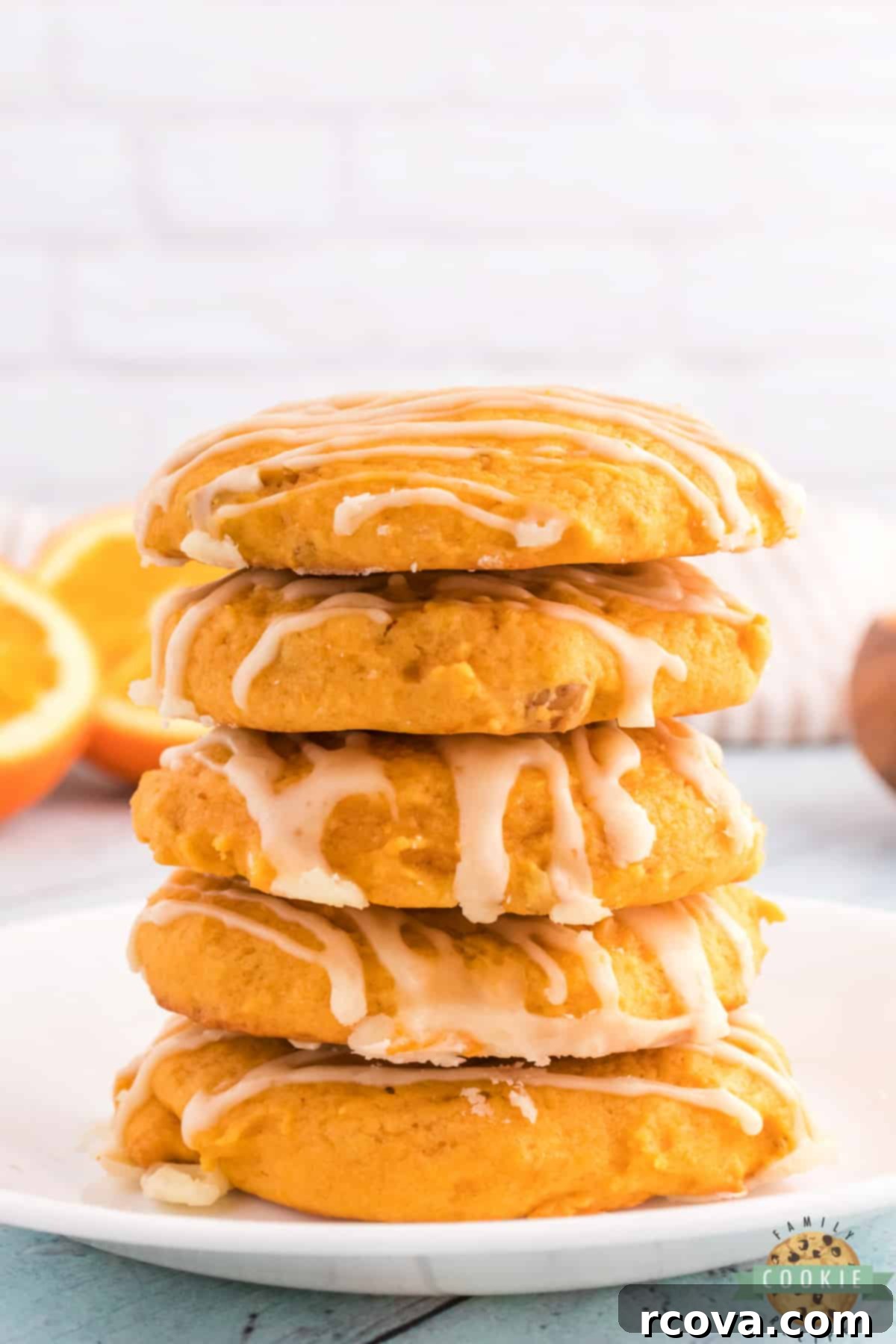 Golden Pumpkin Cookies 8 A beautiful stack of Orange Pumpkin Cookies, generously drizzled with a bright orange glaze, ready to be served.