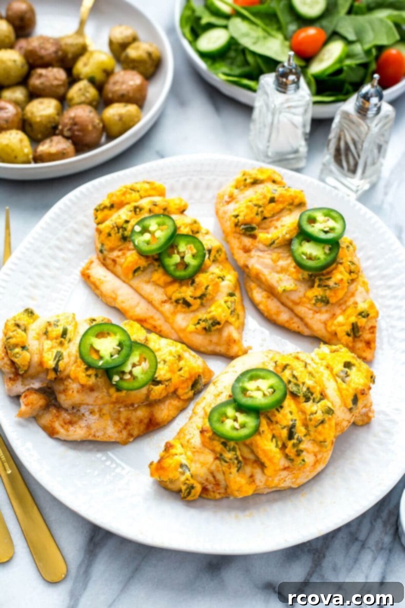 Jalapeno Popper Stuffed Hasselback Chicken 8 Hasselback Jalapeno Popper Chicken, elegantly presented on a platter with fresh garnishes, ready to serve at a gathering.