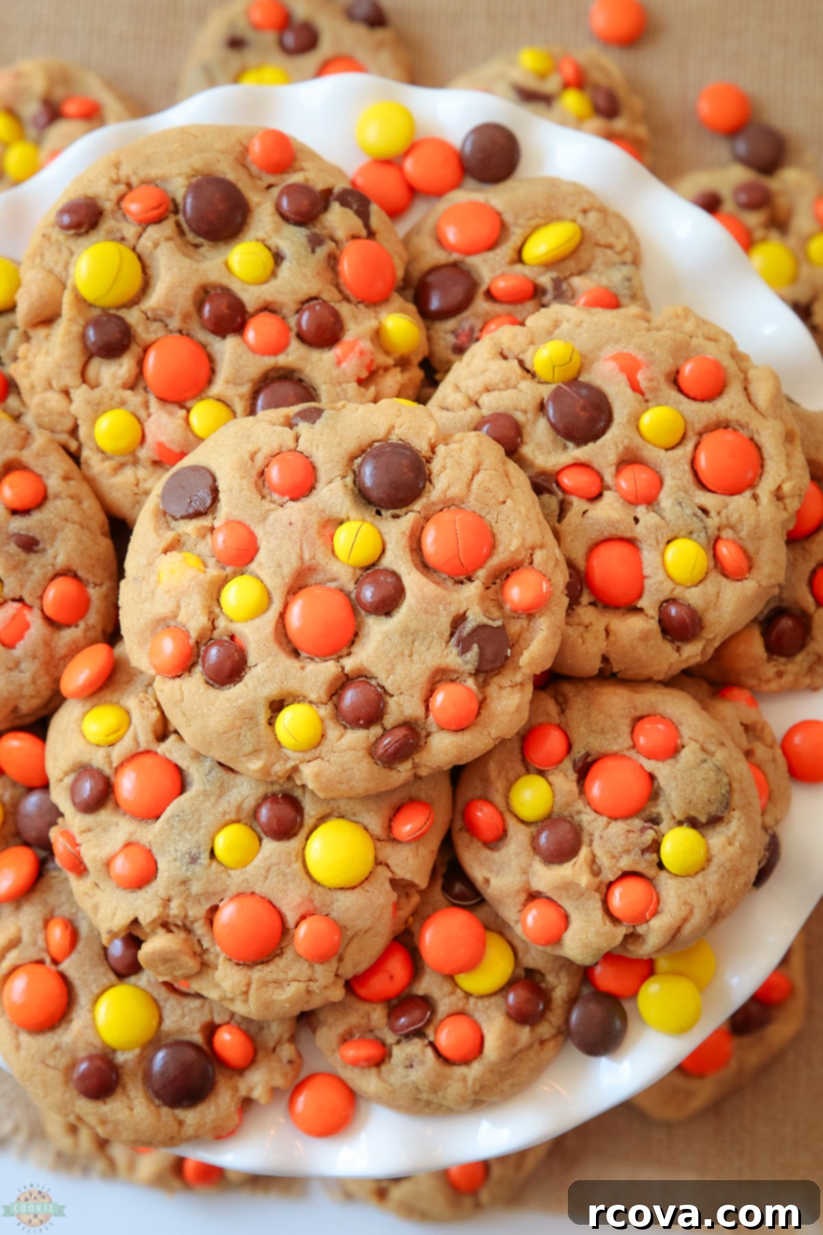 REESE'S PEANUT BUTTER COOKIES 5 A stack of golden-brown Reese's Peanut Butter Cookies on a white plate, garnished with more Reese's candies, emphasizing their irresistible appeal