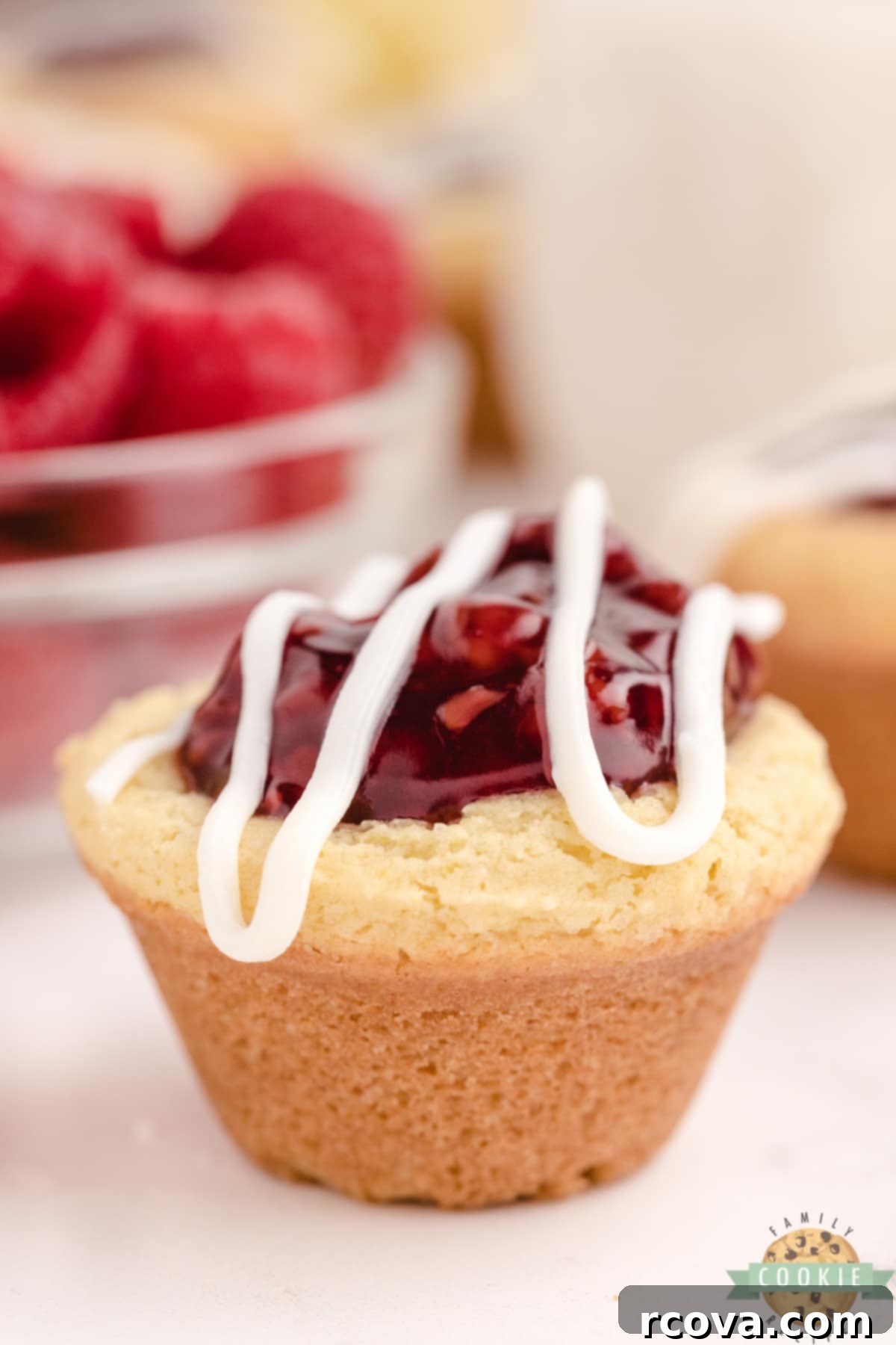 Zesty Berry Cookie Bites 2 Lemon Raspberry Cookie Cups are made with a simple lemon cookie recipe and raspberry pie filling. Drizzle a little white chocolate on top for a bite sized cookie cup recipe that is impressive and delicious!