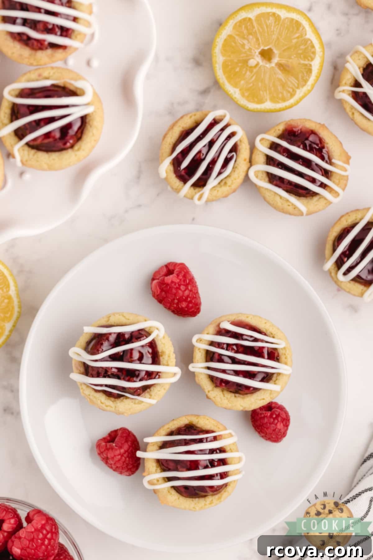 Zesty Berry Cookie Bites 13 Lemon Raspberry Cookie Cups are made with a simple lemon cookie recipe and raspberry pie filling. Drizzle a little white chocolate on top for a bite sized cookie cup recipe that is impressive and delicious!