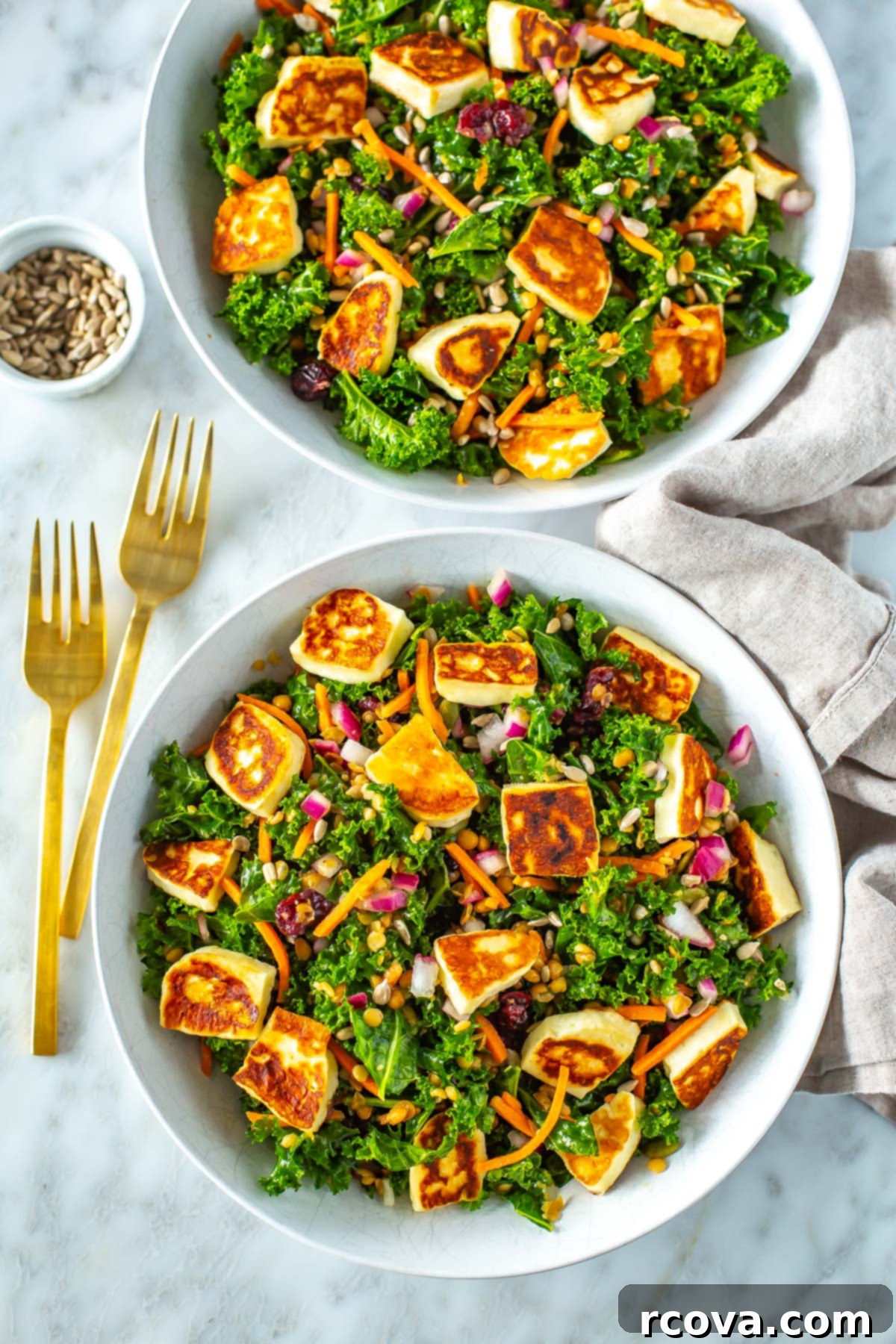 40+ Easy and Healthy Meal Prep Lunches for Work 29 Two bowls filled with kale salad topped with cooked halloumi cheese and lentils.