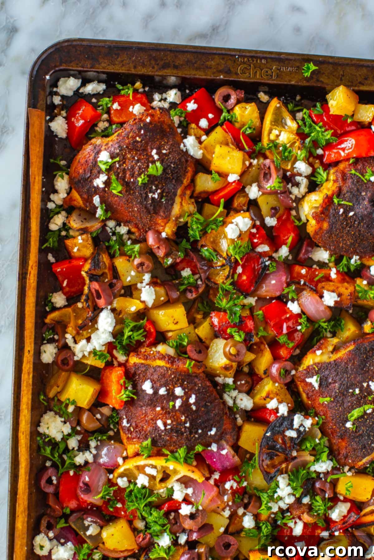 Sheet Pan Magic: Effortless Dinner Ideas 17 A close-up of beautifully baked chicken thighs on a sheet pan with tender vegetables and potatoes.